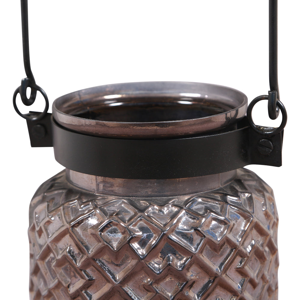 Glass lantern with textured design and black metal accents on a white background
