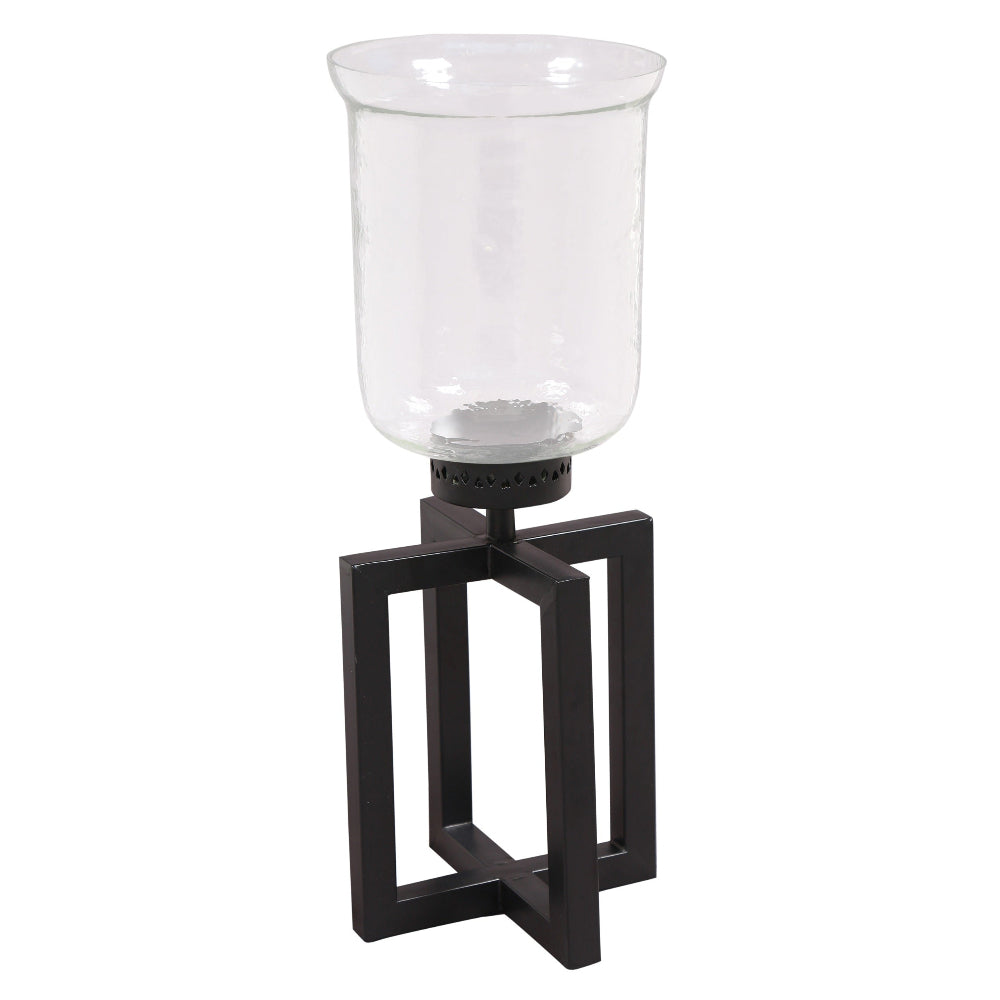 Clear glass candle holder with black metal base on a white background