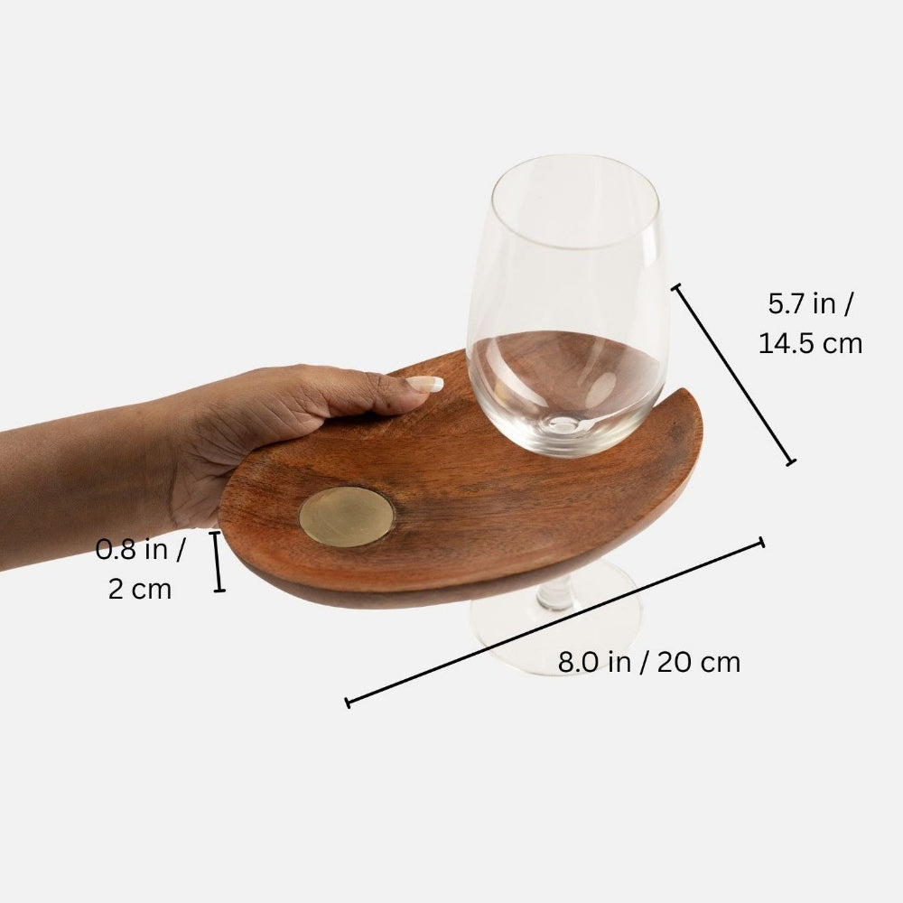 Wooden tray held by a hand with dimensions indicated, featuring a glass on a white background.