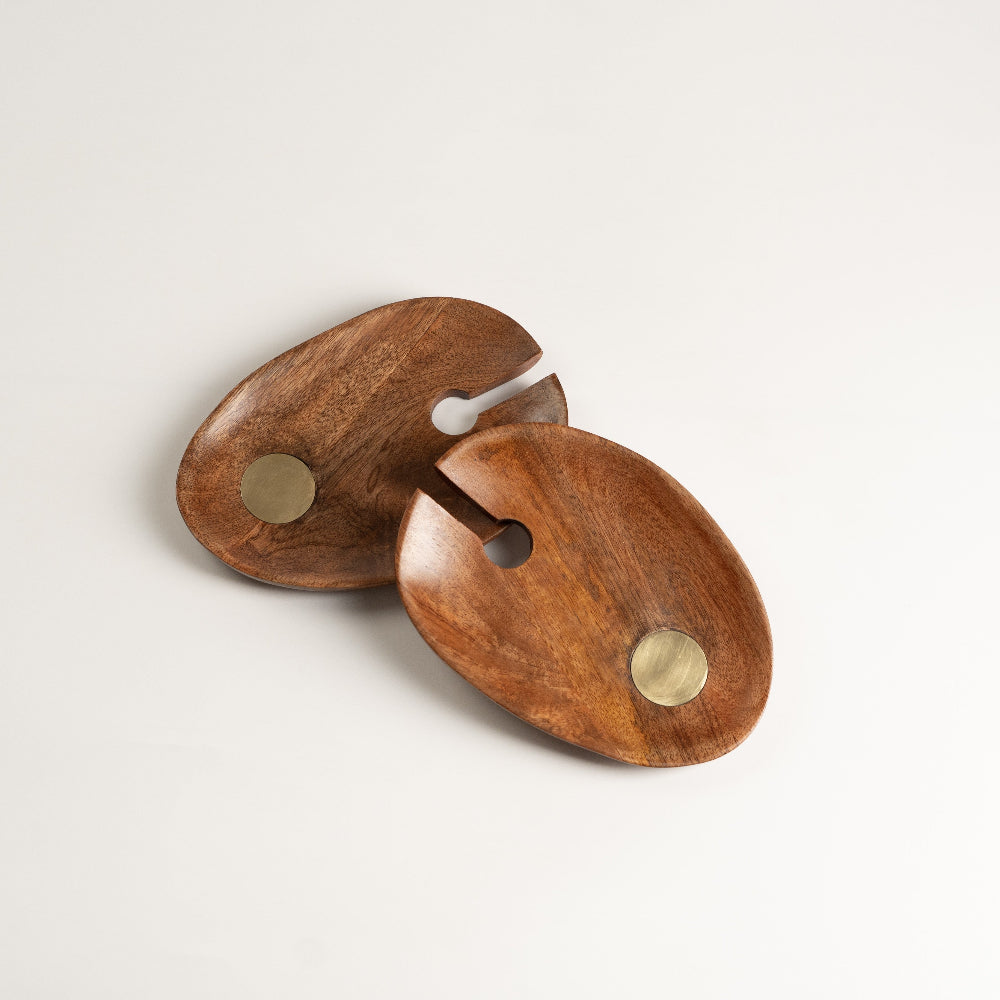 Wooden wall hook with brass accents on a light background