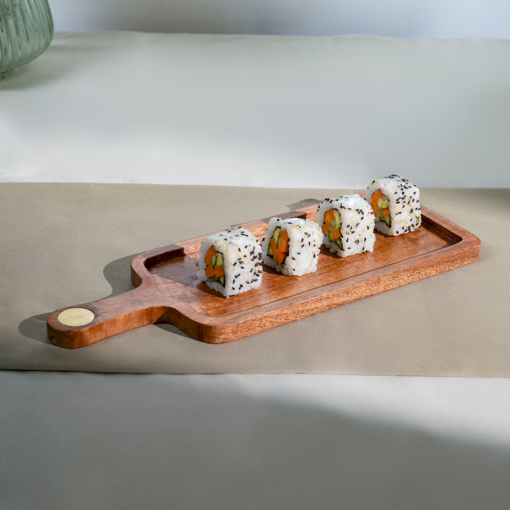 Wooden tray with sushi rolls on a light surface