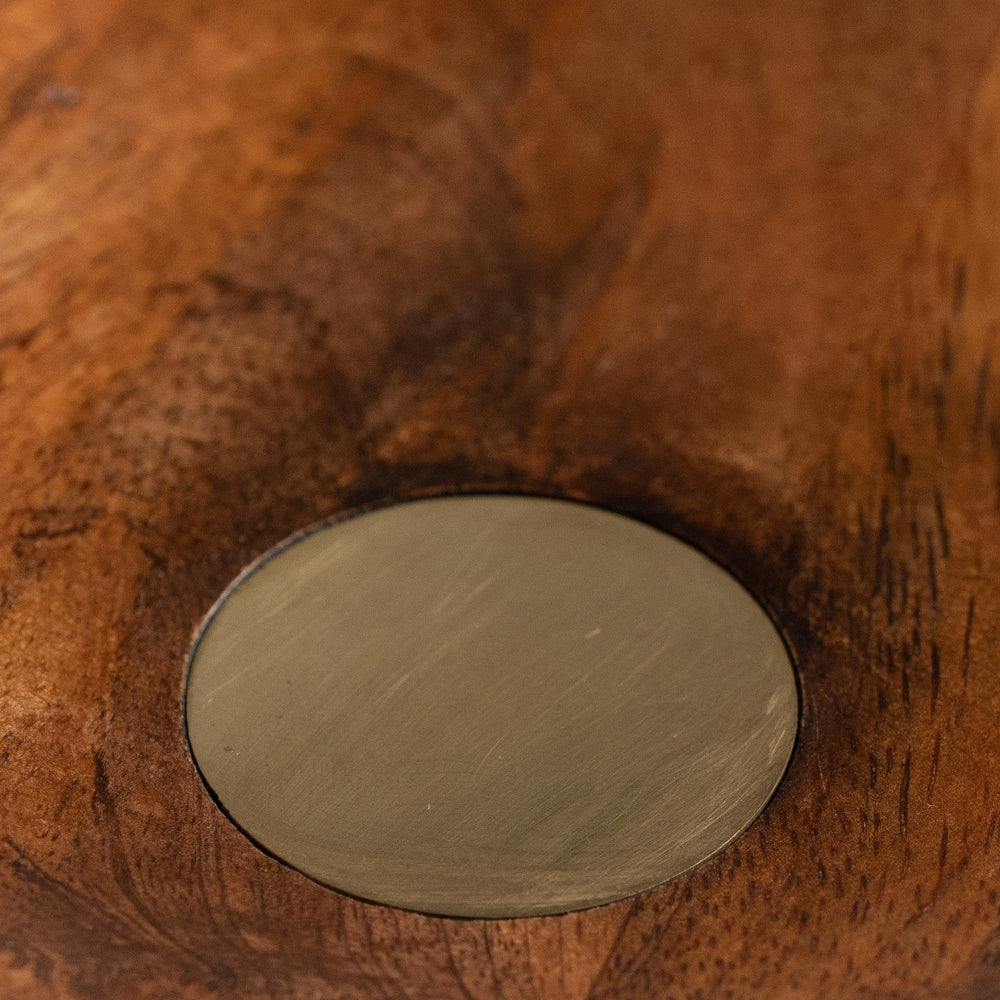 Close-up of a wooden surface with a circular metal inset