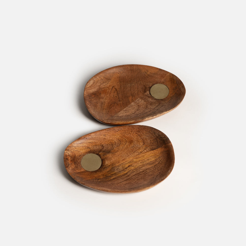 Two wooden coasters with metal centers on a white background