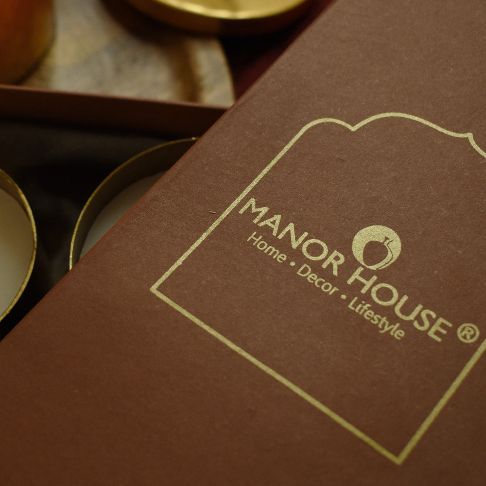 Close-up of a brown box with 'Manor House' branding on a blurred background.