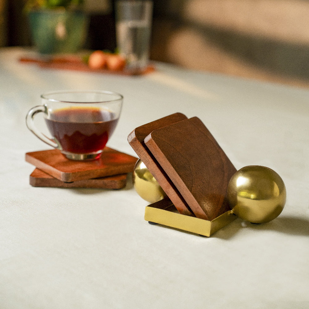 Wooden coasters with a cup of tea on a table with decorative elements.