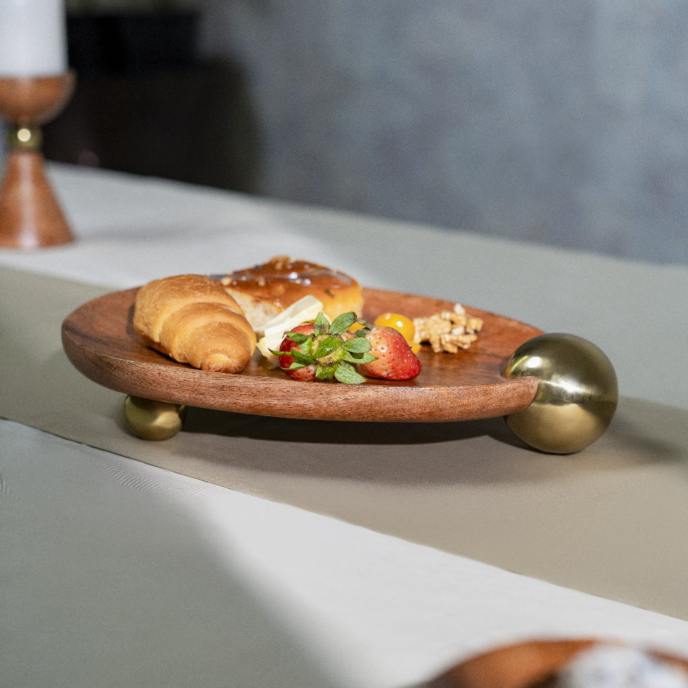 Wooden plate with pastries and fruit on a light surface