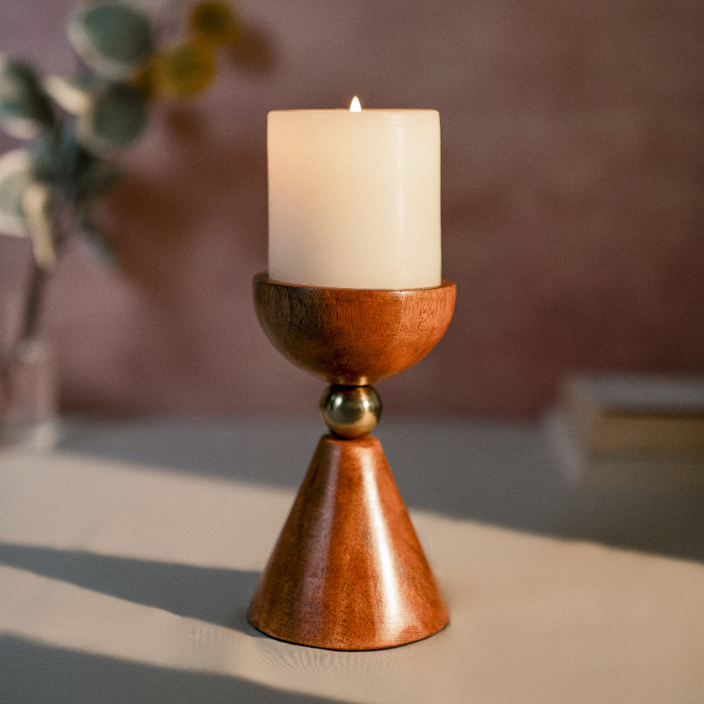 Wooden candle holder with a lit candle on a neutral background