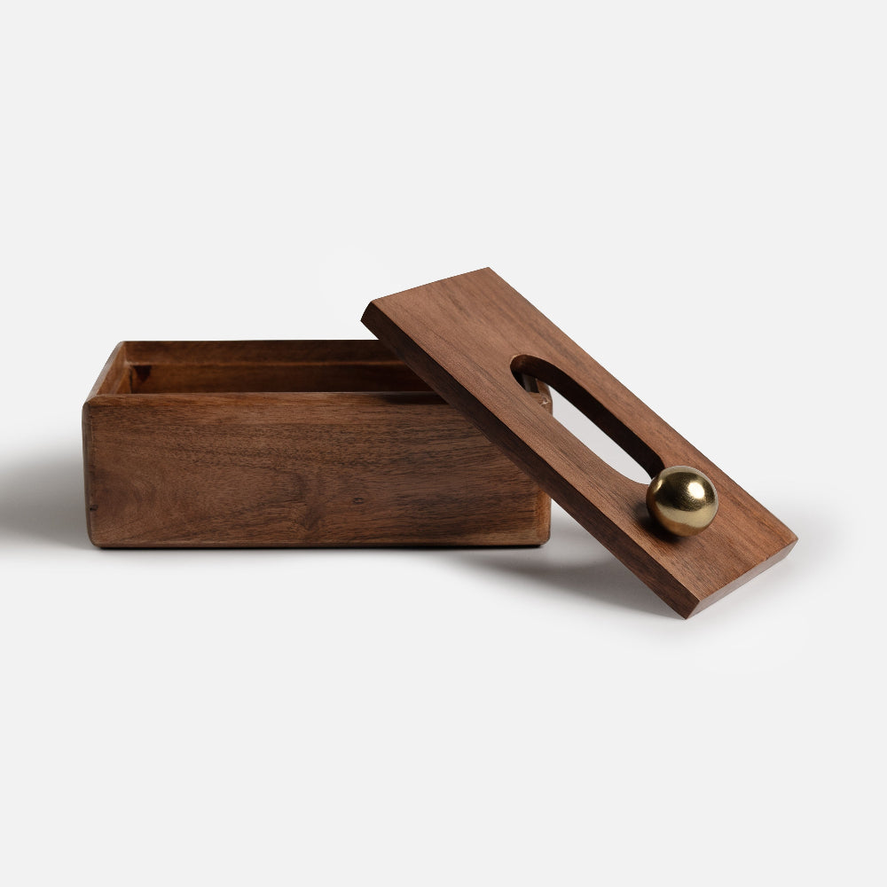 Wooden box with a gold ball and handle on a white background