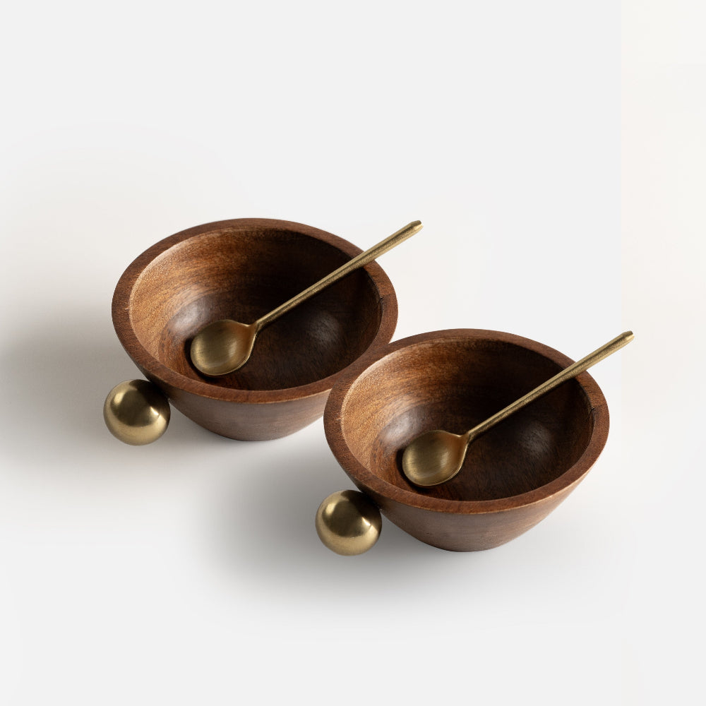 Two wooden bowls with gold spoons on a white background