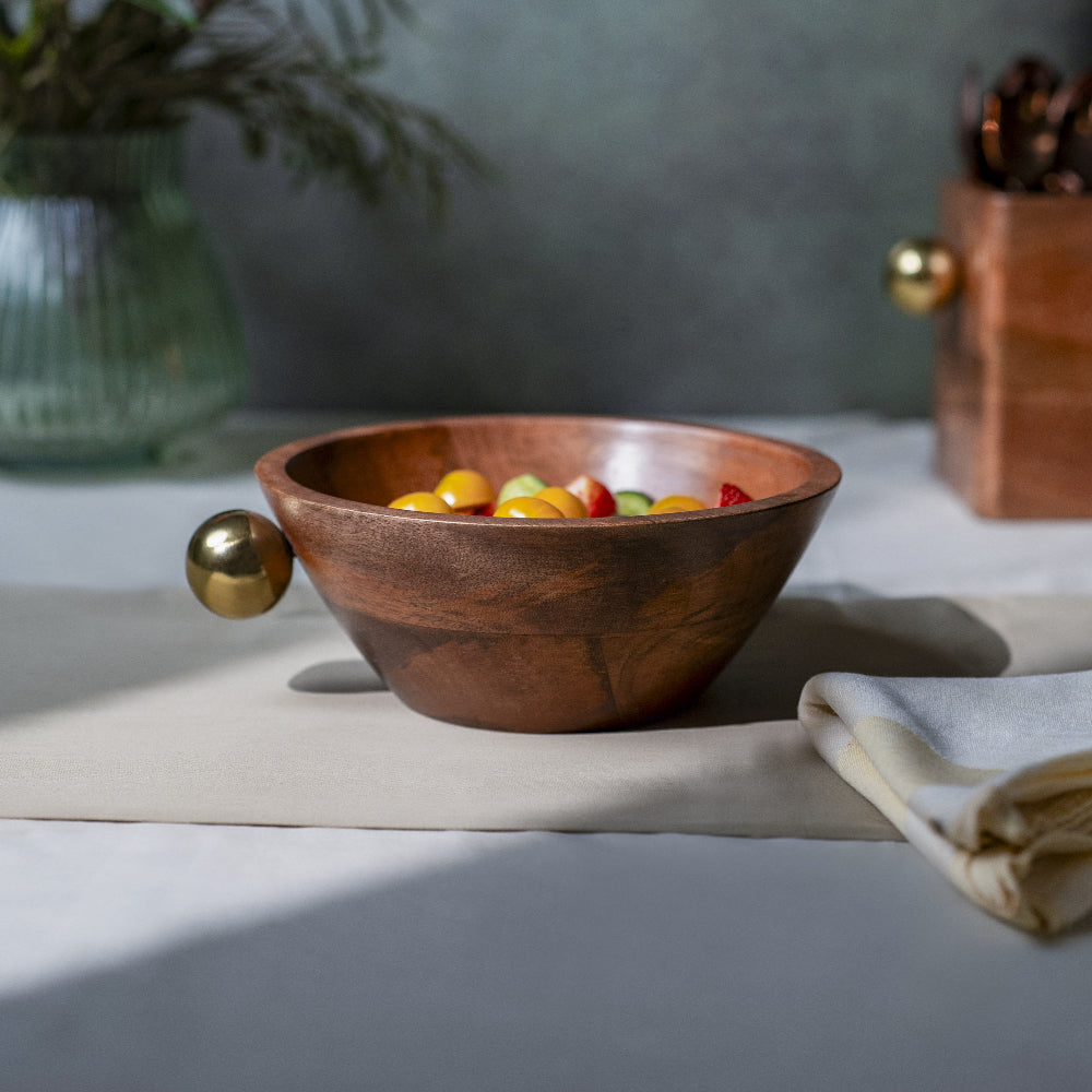 Wooden bowl with colorful candies on a table with a neutral background